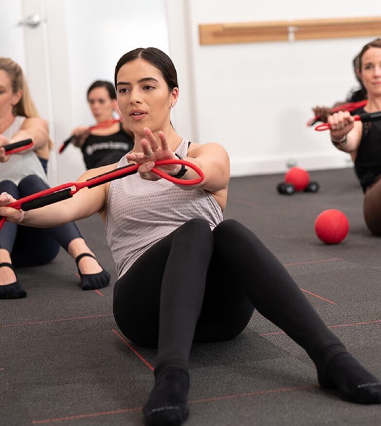 Group sitting on the floor while working out with resistance bands